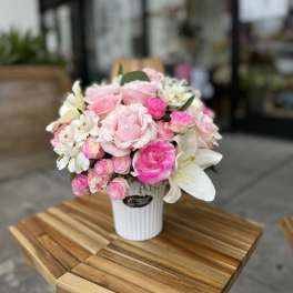 Pink and white flower arrangement in a white vase