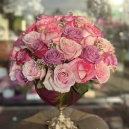 Pink and lavender rose bouquet in a gold pedestal vase