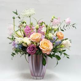 Mixed pastel bouquet in a purple glass vase