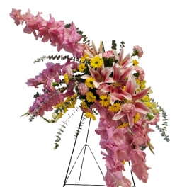 Pink and yellow floral standing spray on a black easel