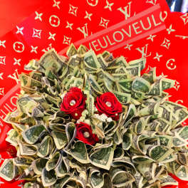 Bouquet of folded dollar bills with red roses on a red patterned background