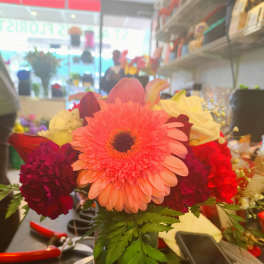 Bright mixed bouquet with a pink gerbera daisy in a glass vase