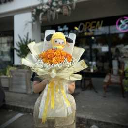 Bouquet of orange roses with a plush character topper