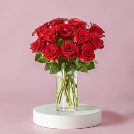 Red roses arranged in a clear glass vase