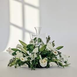White floral arrangement with a clear cross centerpiece