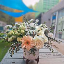 Peach gerbera and white roses in a pink vase