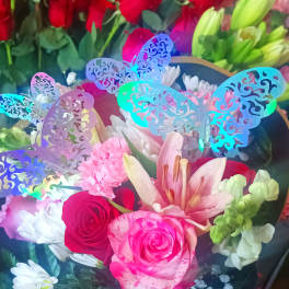 Bouquet of pink and red roses with lilies and white daisies, decorated with butterfly picks