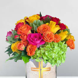 Bright mixed rose bouquet in a glass vase with a cross design