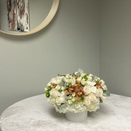 Cream and peach floral arrangement in a white vase