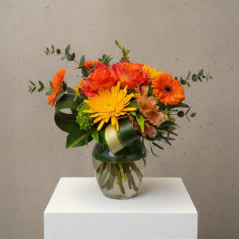 Orange and yellow mixed bouquet in a glass vase