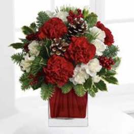Red and white floral arrangement in a clear glass vase