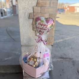 Valentine's Day gift basket with a heart balloon, teddy bear, and chocolates