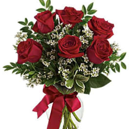 Bouquet of red roses with white filler in a glass vase
