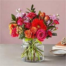 Mixed bouquet of bright flowers in a clear glass vase