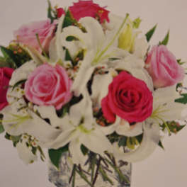 Pink and white rose bouquet in a square glass vase
