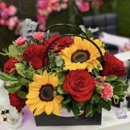 Basket arrangement of red roses and sunflowers