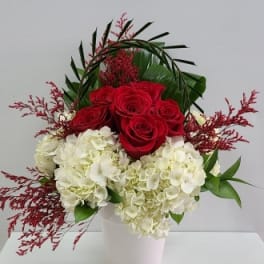 Red roses and white hydrangeas in a white vase