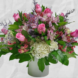 Pink roses and mixed blooms in a white vase