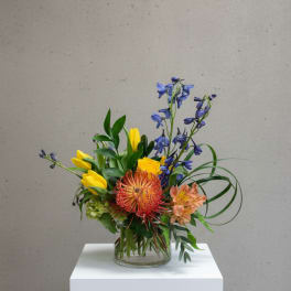 Colorful mixed flower arrangement in a clear glass vase