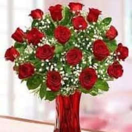 Bouquet of red roses in a red glass vase