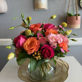 Mixed pink and orange roses in a glass vase