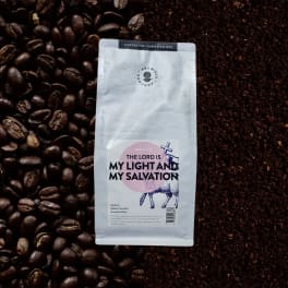Bag of ground coffee on a background of coffee beans and grounds