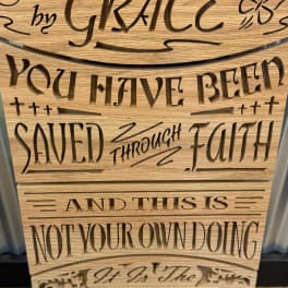 Wooden sign with cutout text reading "you have been saved through faith."