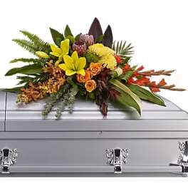 Colorful floral spray arranged on a silver casket