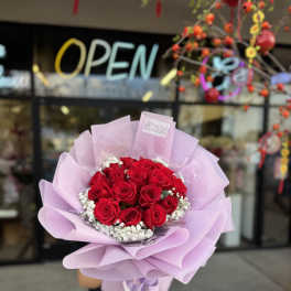 Bouquet of red roses wrapped in light pink paper