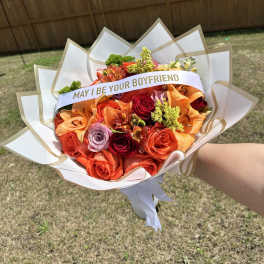 Bouquet of orange and red roses with a "MAY I BE YOUR BOYFRIEND" sash