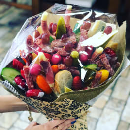 Bouquet of assorted salami, cheese, and grapes wrapped in decorative paper