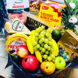 Gift basket with fruit, cheese, chocolates, and a pineapple centerpiece