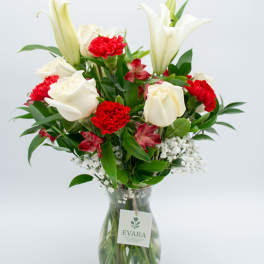 White lilies and red carnations in a glass vase