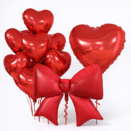 Cluster of red heart balloons with a large red bow balloon