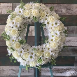 White rose and daisy wreath on a teal easel