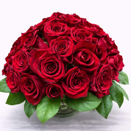 Round bouquet of red roses in a glass vase