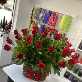 Basket arrangement of red roses with a red ribbon