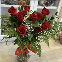 Bouquet of red roses with baby's breath in a glass vase