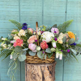 Mixed pastel flower arrangement in a wicker basket