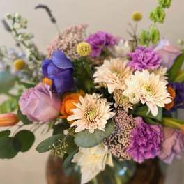 Mixed bouquet of pastel and bright flowers in a vase