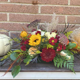Autumn floral centerpiece with pumpkins on a table