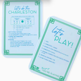 Two printed game instruction cards with blue and green text