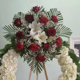Standing floral wreath with red roses, white lilies, and white hydrangeas