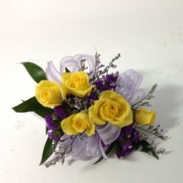 Yellow roses with purple filler and a lavender ribbon bow
