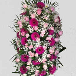 Standing spray of pink roses and magenta gerbera daisies with white filler flowers