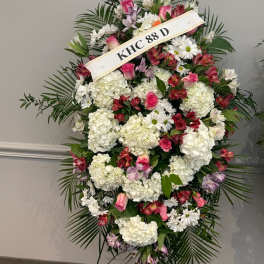 Standing floral spray with white and pink flowers on an easel
