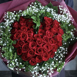 Heart-shaped bouquet of red roses with white baby's breath