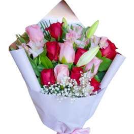 Bouquet of pink and red roses with lilies wrapped in pale lavender paper