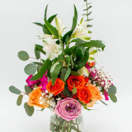 Mixed bouquet of roses and lilies in a glass vase