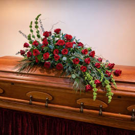 Red rose casket spray on a wooden coffin